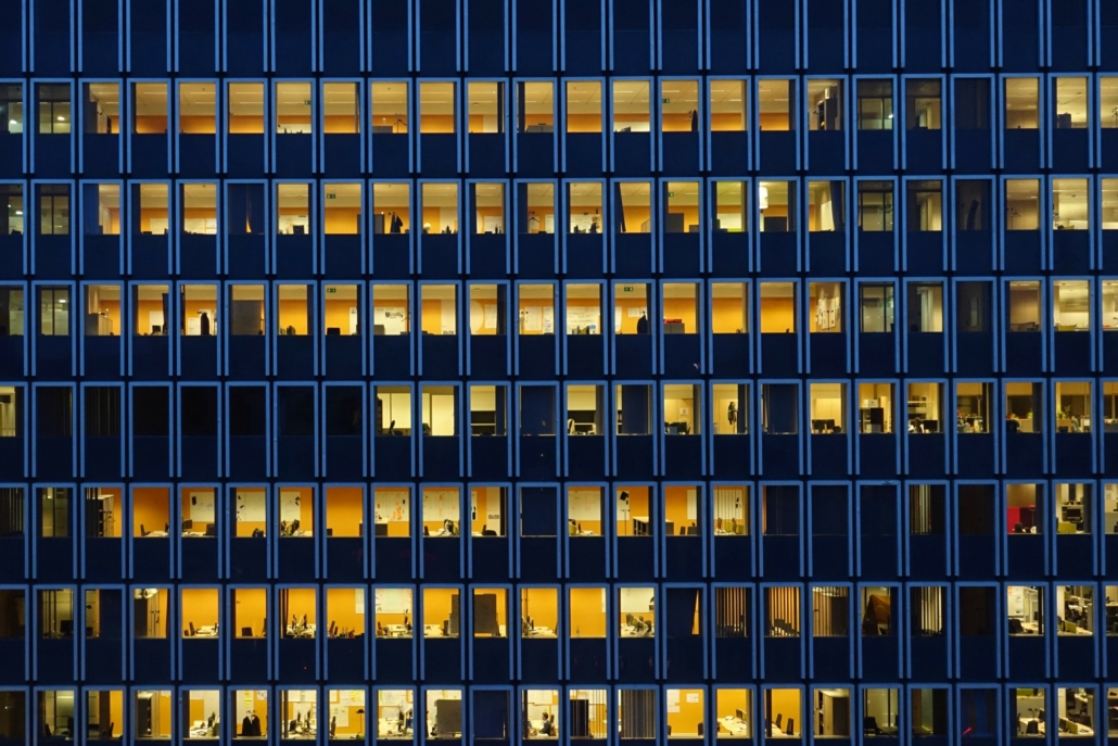 Bürogebäude nach Einsetzen der Dunkelheit, in vielen Büros brennt noch Licht