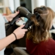 Friseursalon: Eine Person föhnt die Haare einer Frau, Photo: Adam Winger, unsplash
